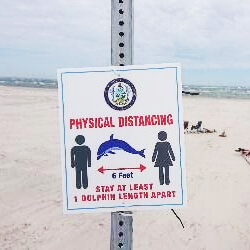 social distance sign that says stay at least 1 dolphin length apart